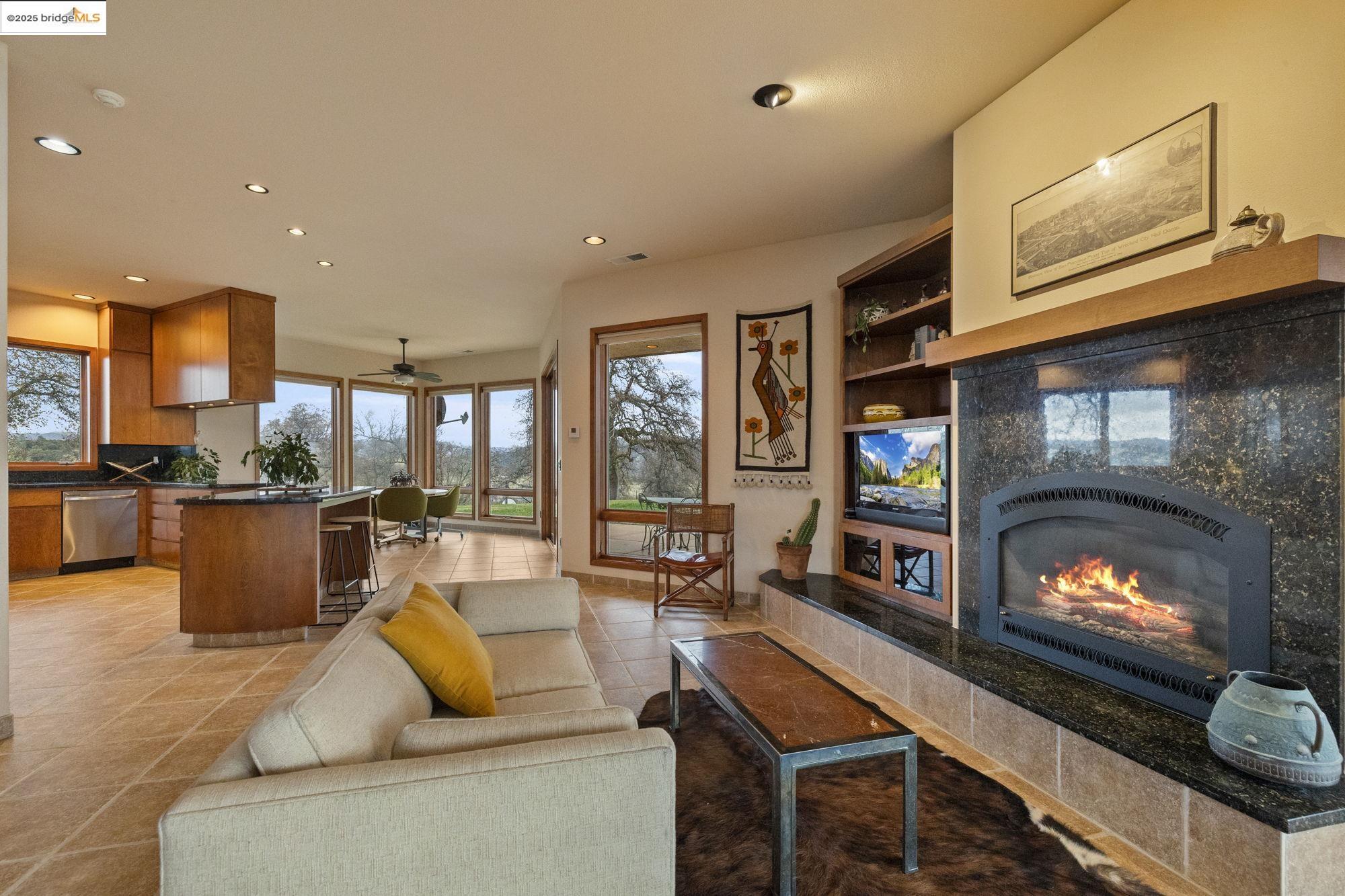 25775 Powell Ranch Road Sonora, CA 95370 - Photo 18 of 60 a living room with furniture a flat screen tv and a fireplace
