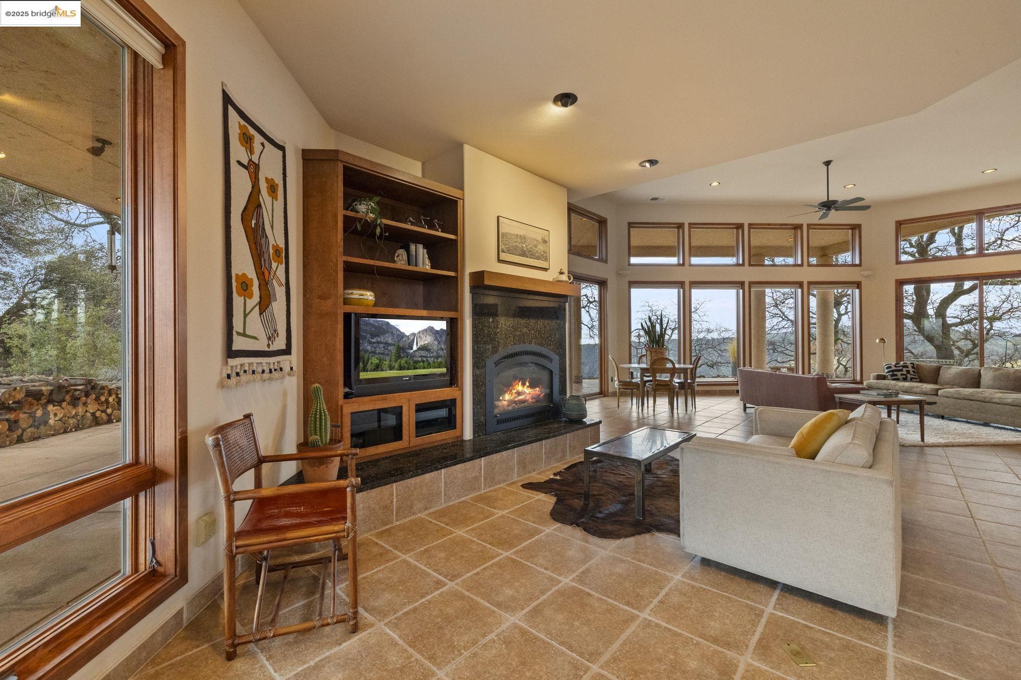 25775 Powell Ranch Road Sonora, CA 95370 - Photo 19 of 60 a living room with fireplace furniture and a floor to ceiling window