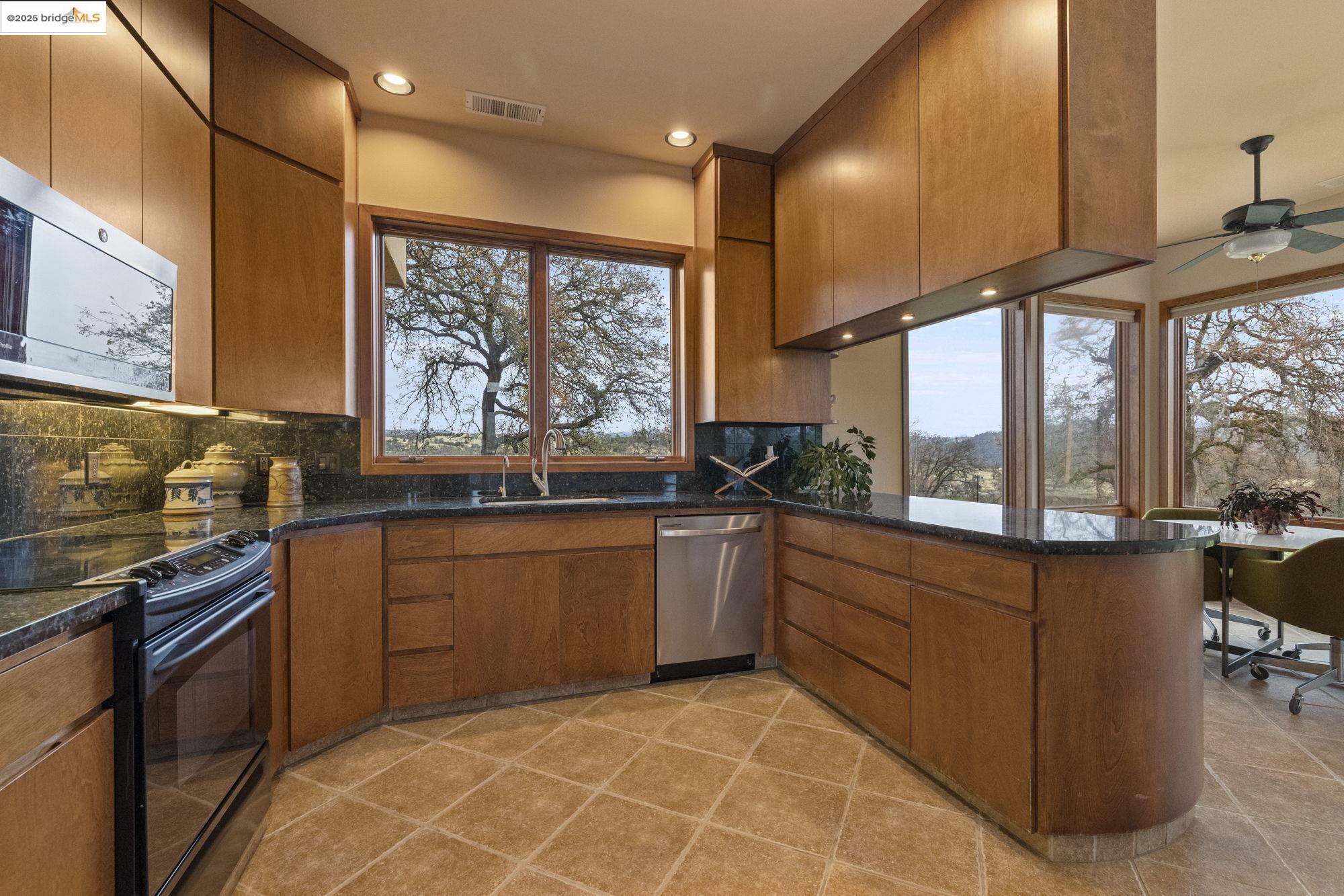 25775 Powell Ranch Road Sonora, CA 95370 - Photo 22 of 60 a kitchen with stainless steel appliances granite countertop a stove a sink and a refrigerator