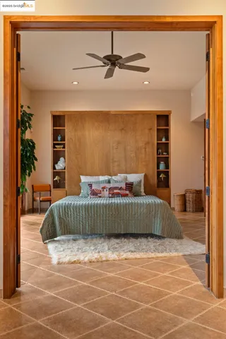 a bedroom with a bed and large windows