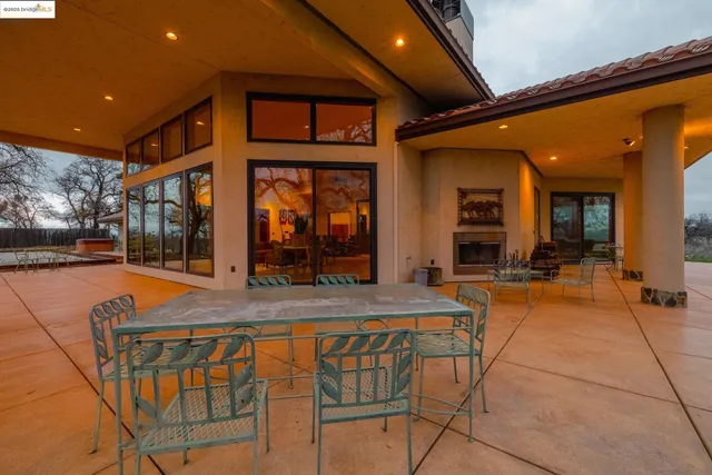 a view of a patio with table and chairs under an umbrella