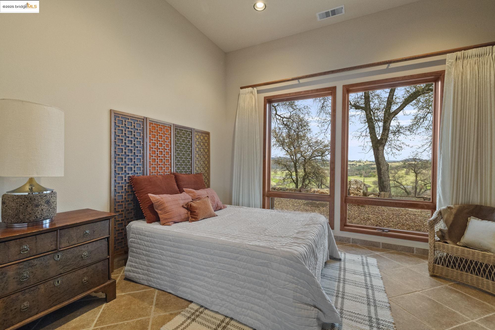 25775 Powell Ranch Road Sonora, CA 95370 - Photo 41 of 60 a bedroom with a bed and wooden floor