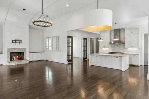 an empty room with wooden floor and a ceiling fan