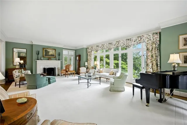 a living room with furniture a large window and a fireplace