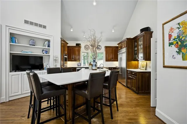 a kitchen with stainless steel appliances granite countertop a sink a stove and a refrigerator