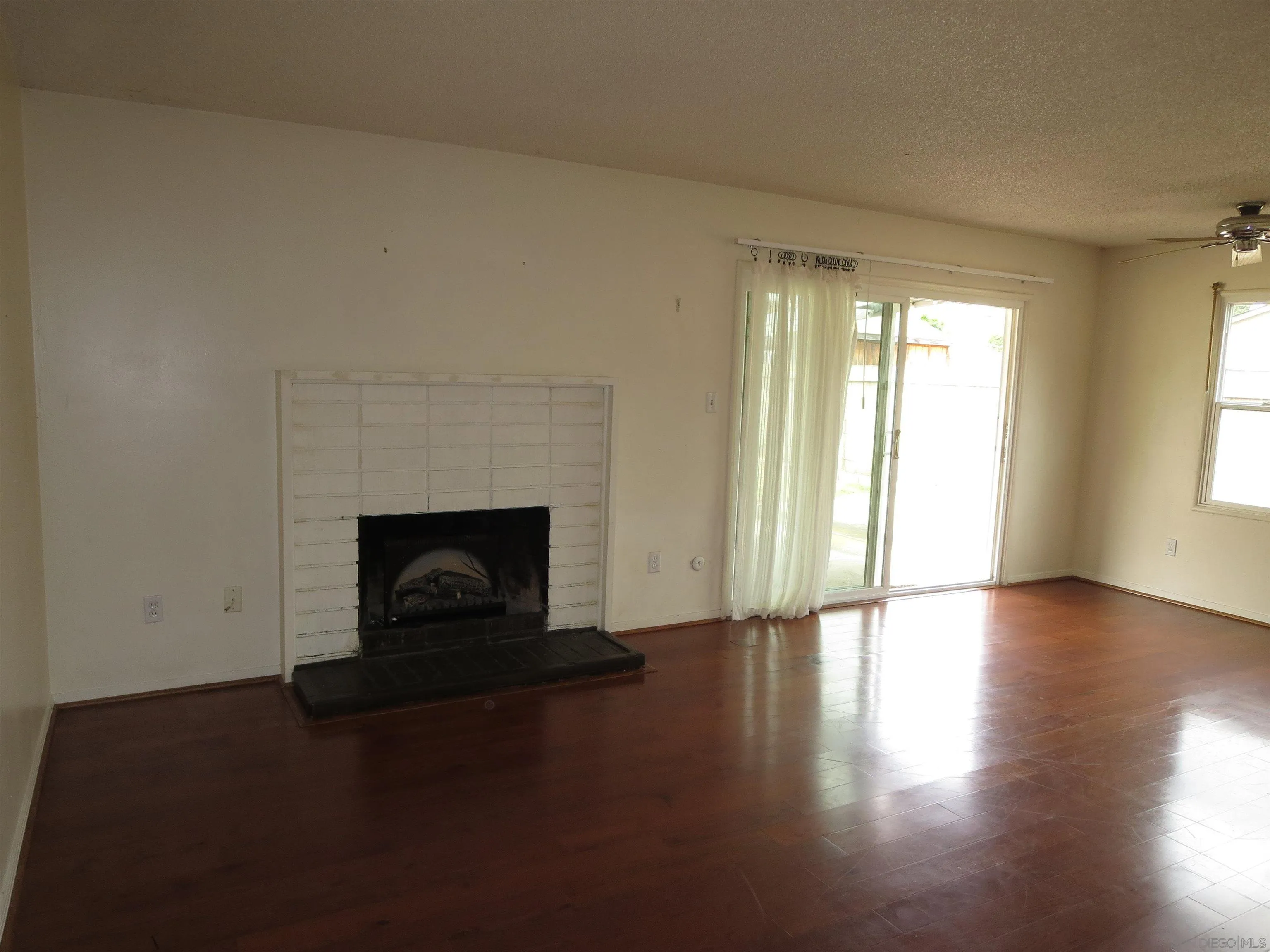 13516 Frame Road Poway, CA 92064 - Photo 20 of 39 a view of a livingroom with a fireplace wooden floor and window