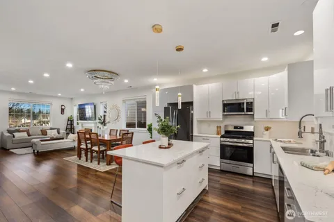 a large white kitchen with stainless steel appliances