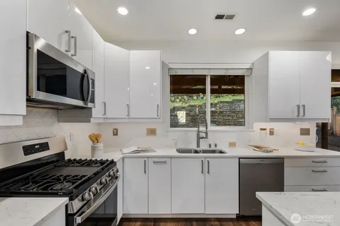 a kitchen with a sink stove top oven and cabinets