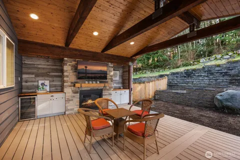 a view of a chairs and table in the patio next to a yard