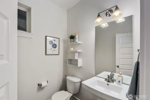 a bathroom with a toilet a sink and mirror