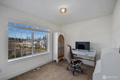 a view of a workspace with furniture and a window