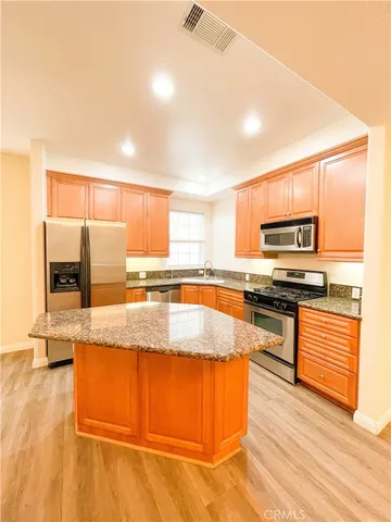 a large kitchen with granite countertop a stove a sink and a microwave