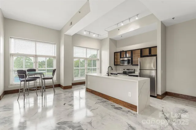 a living room with furniture a dining table and a large window