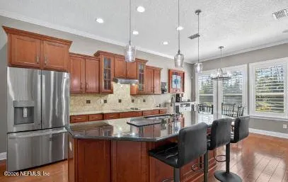 a kitchen with stainless steel appliances granite countertop a sink a stove and a refrigerator