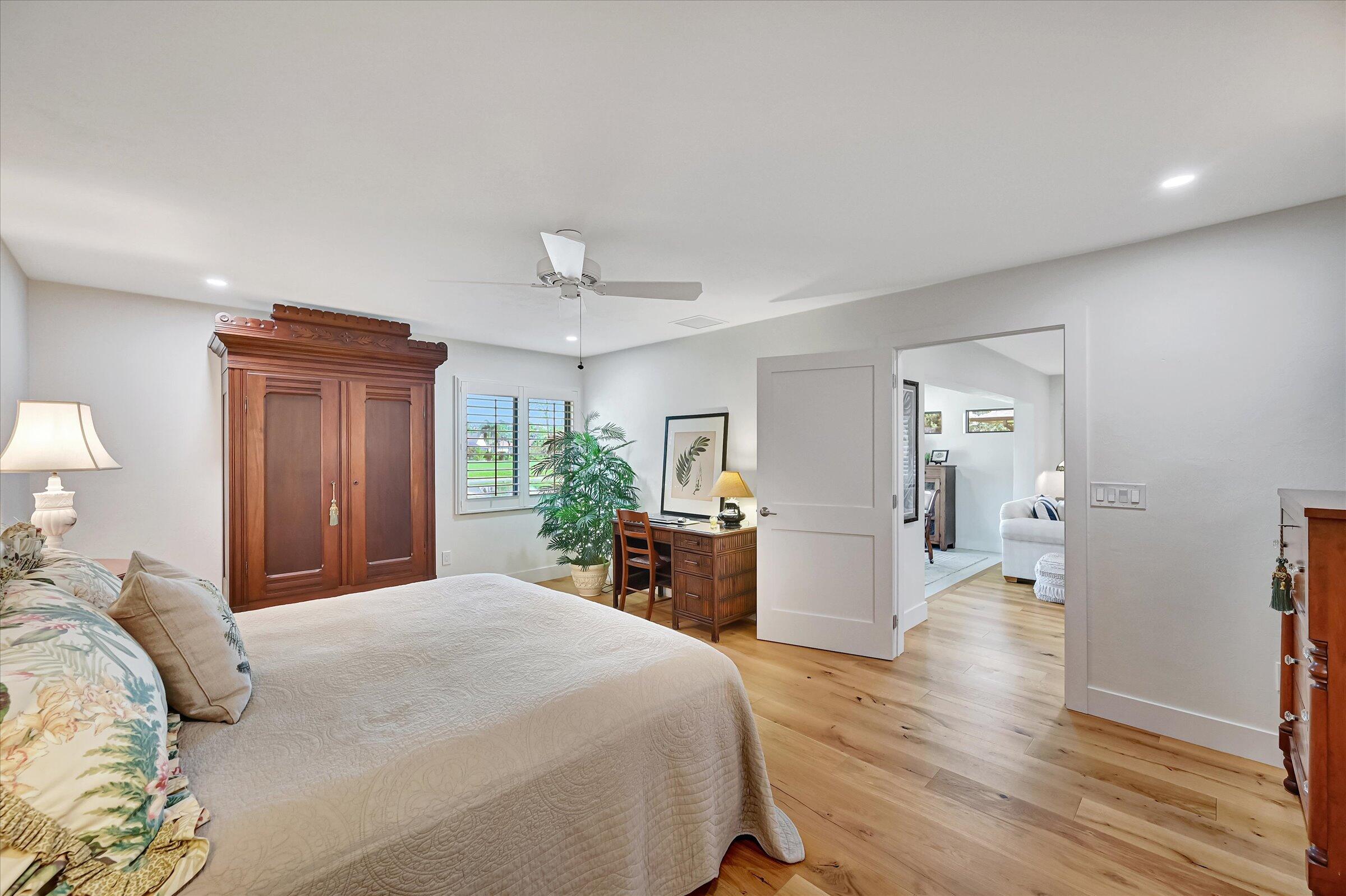 535 Augusta Boulevard, Unit 4 Naples, FL 34113 - Photo 29 of 44 a bedroom with a large bed and wooden floor