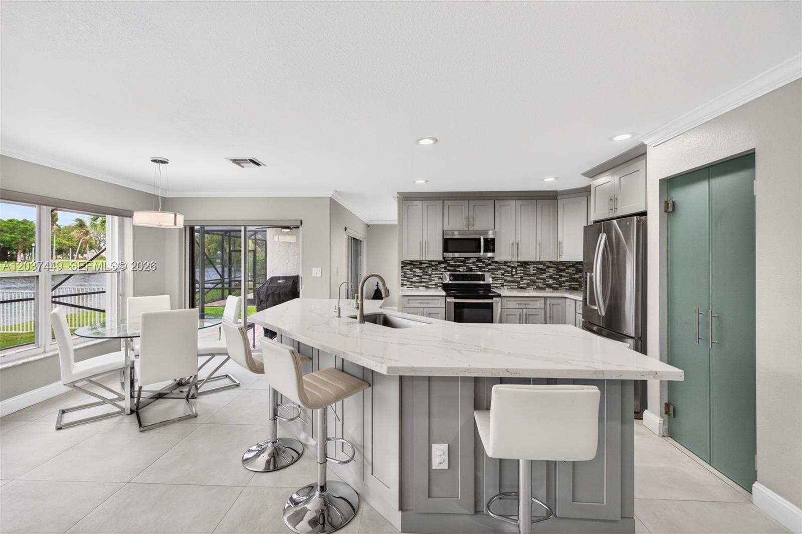 17488 Southwest 28th Court Miramar, FL 33029 - Photo 15 of 50 a kitchen with stainless steel appliances a dining table chairs and a refrigerator