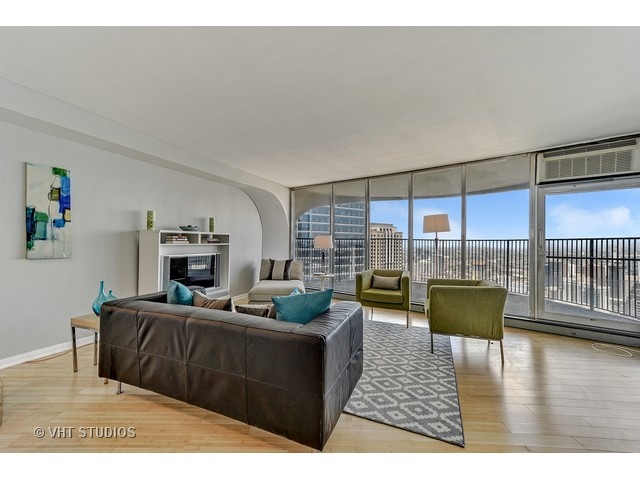 300 North State Street, Unit 5518 Chicago, IL 60654 - Photo 2 of 16 a living room with furniture large window and a fireplace