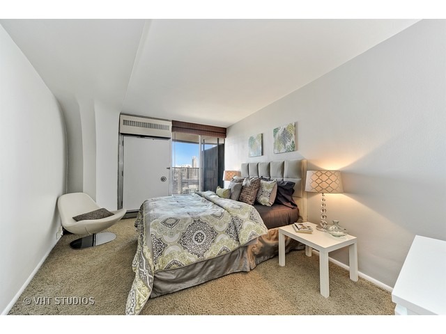 300 North State Street, Unit 5518 Chicago, IL 60654 - Photo 11 of 16 a bedroom with a bed and a chair