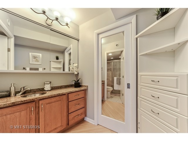 300 North State Street, Unit 5518 Chicago, IL 60654 - Photo 12 of 16 a bathroom with a granite countertop sink mirror and a