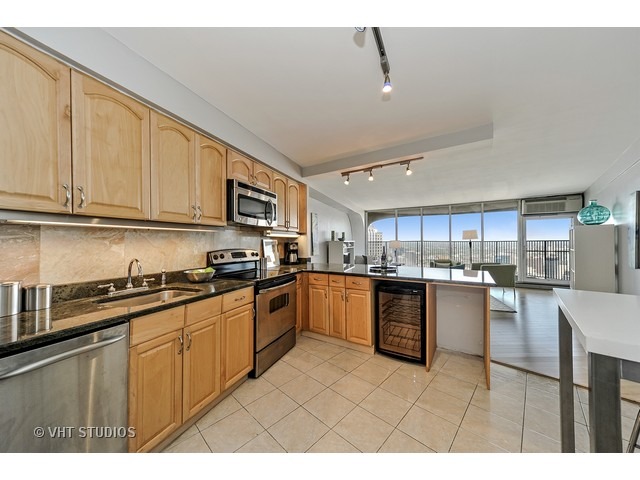 300 North State Street, Unit 5518 Chicago, IL 60654 - Photo 6 of 16 a kitchen with stainless steel appliances granite countertop a stove sink and cabinets