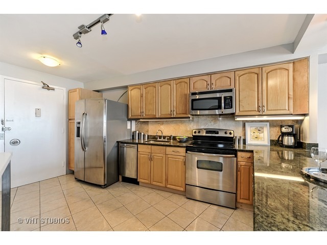 300 North State Street, Unit 5518 Chicago, IL 60654 - Photo 8 of 16 a kitchen with stainless steel appliances granite countertop a refrigerator a stove top oven a sink and dishwasher