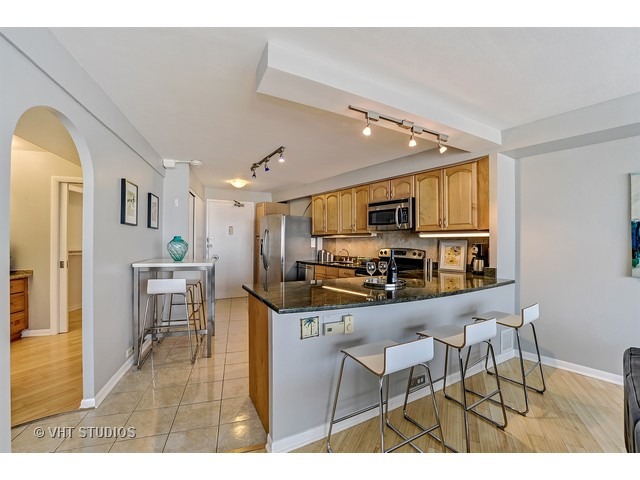 300 North State Street, Unit 5518 Chicago, IL 60654 - Photo 9 of 16 a living room with stainless steel appliances kitchen island granite countertop furniture and a view of kitchen