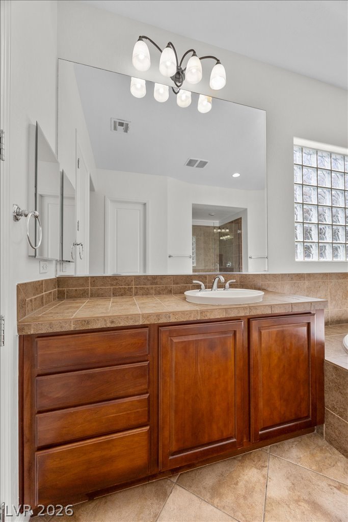 2125 De Rouge Avenue Henderson, NV 89044 - Photo 52 of 96 A rich wooden vanity with ample storage defines this well-appointed bathroom.