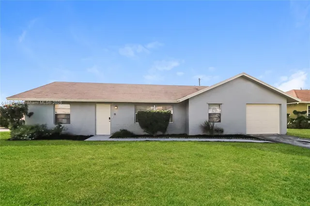 a front view of house with yard and green space