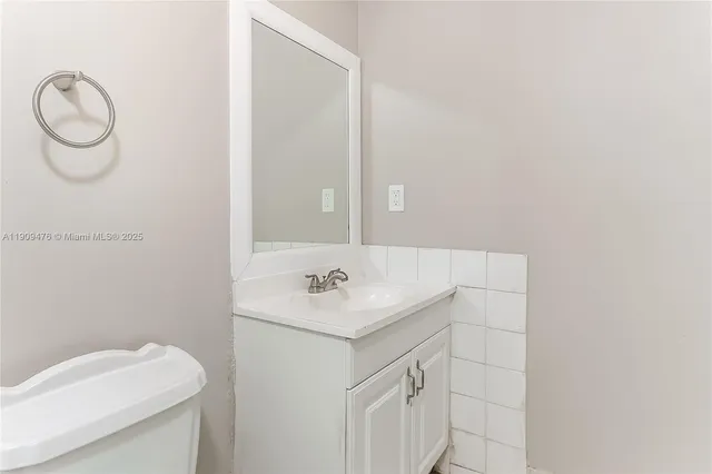 a bathroom with a sink vanity and toilet