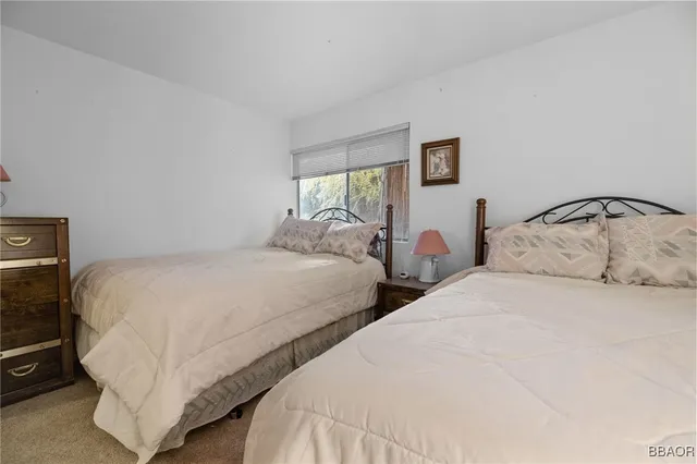 a bedroom with two beds and a window