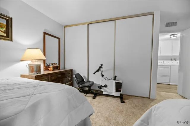 a bedroom with a bed a lamp and a closet