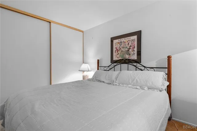 a bedroom with a large bed and a painting on the wall