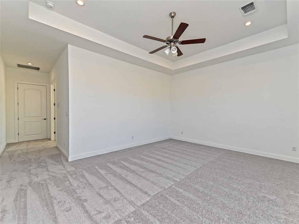 270 Prairie Clover Drive Dripping Springs, TX 78620 - Photo 18 of 28 Empty room with light carpet, a tray ceiling, a ceiling fan, and recessed lighting