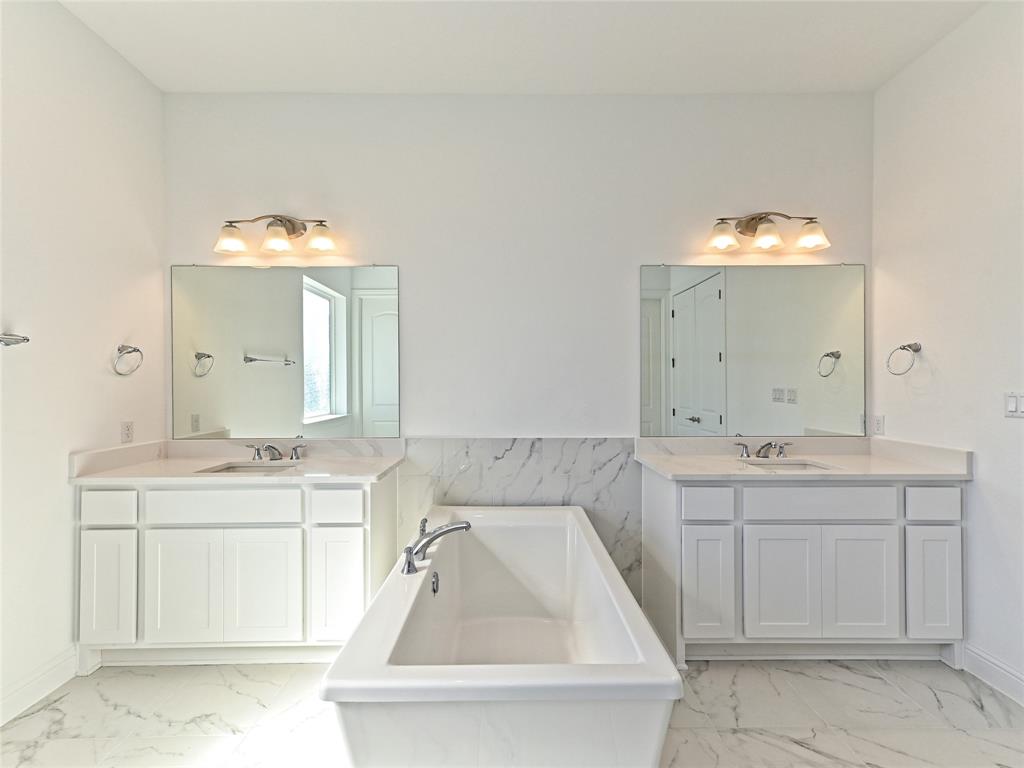 270 Prairie Clover Drive Dripping Springs, TX 78620 - Photo 20 of 28 Bathroom with a freestanding tub, two vanities, and light marble finish flooring