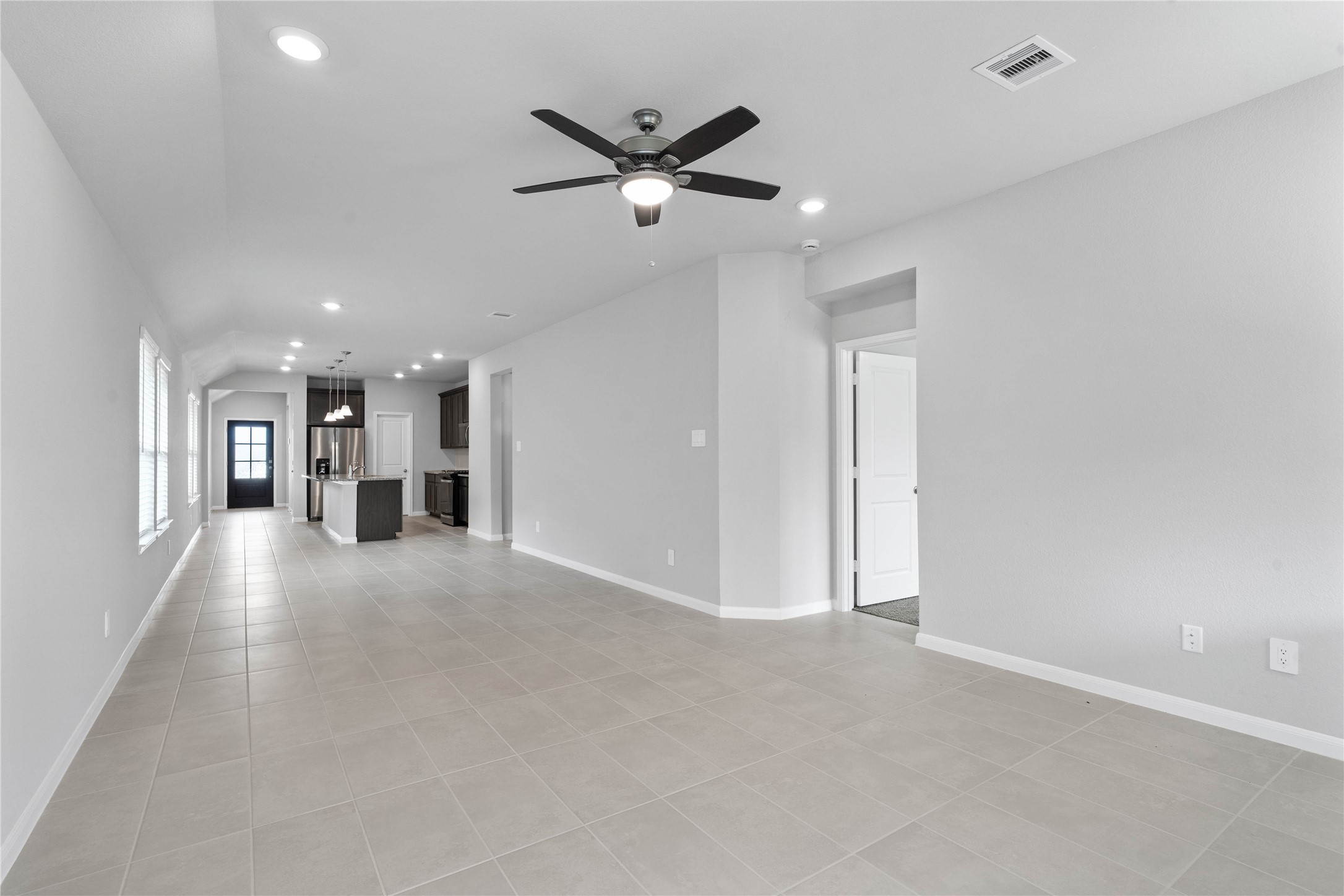 19555 Montgomery Rdg Way Montgomery, TX 77316 - Photo 25 of 38 This expansive view from the back of the house showcases a seamless, open-concept layout that creates a warm and inviting path for guests, drawing the eye past the heart of the home toward the welcoming front entryway.