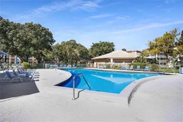 a view of a swimming pool with a patio and a yard