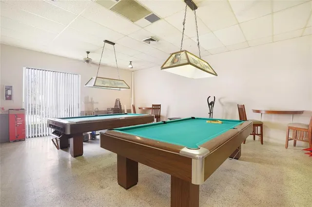 a room with pool table and windows