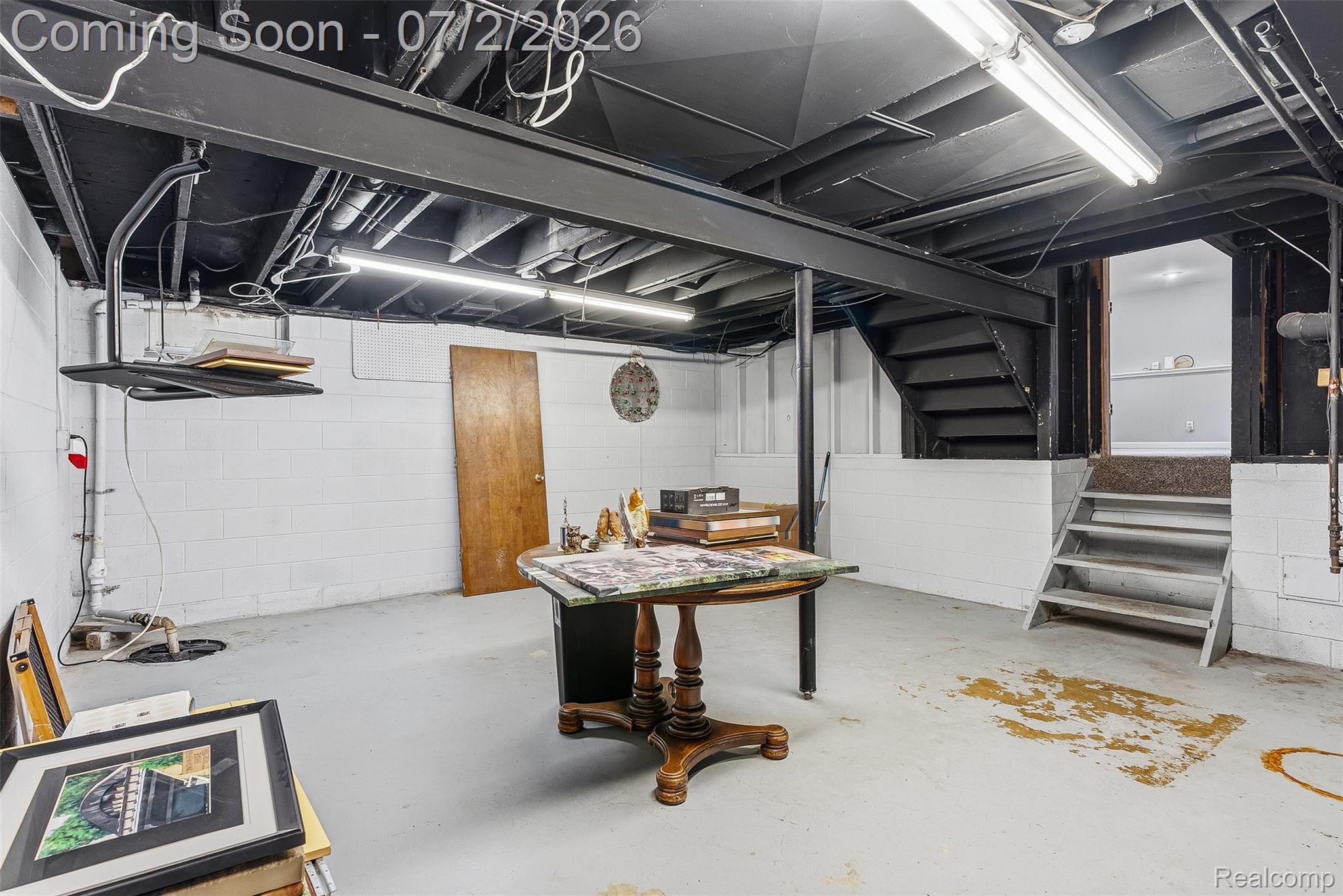 305 East Road Holly, MI 48442 - Photo 29 of 41 Unfinished basement featuring concrete flooring, painted block walls, exposed joists, and overhead fluorescent lighting