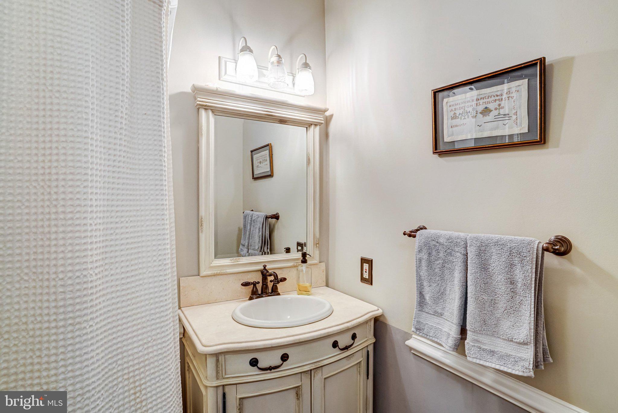 7153 Main Street Clifton, VA 20124 - Photo 43 of 77 a bathroom with a sink and a mirror