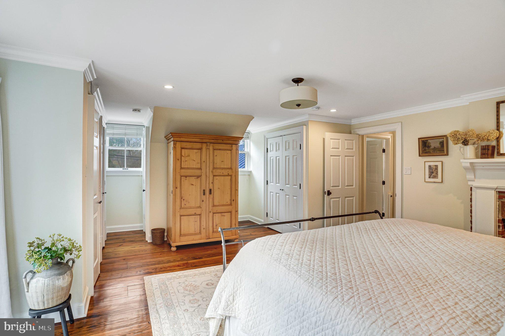 7153 Main Street Clifton, VA 20124 - Photo 48 of 77 a spacious bedroom with a bed and a potted plant