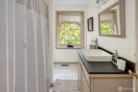 a bathroom with a granite countertop sink a toilet and a window