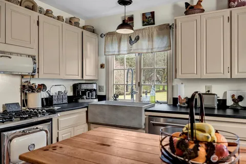 a kitchen with granite countertop a stove a sink dishwasher and cabinets with wooden floor