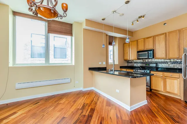 a kitchen with stainless steel appliances granite countertop a refrigerator a sink and dishwasher