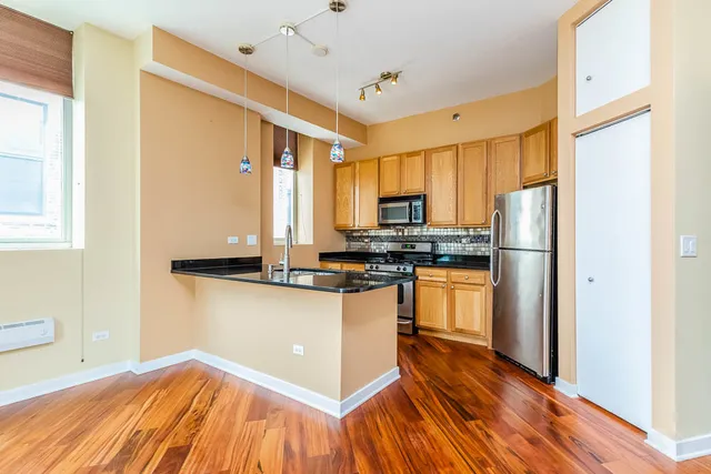 a kitchen with granite countertop a sink stove and refrigerator