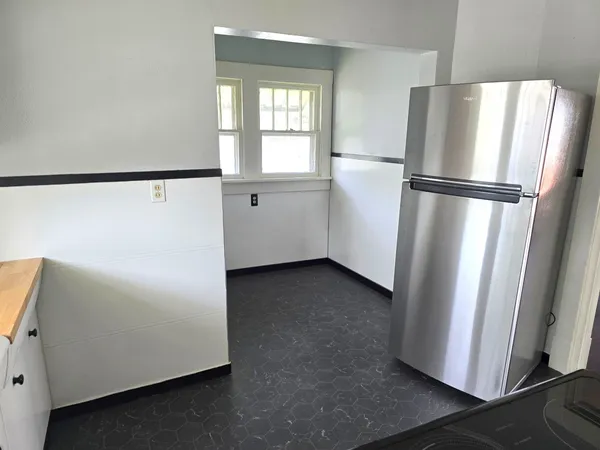 a view of a refrigerator in kitchen and wooden floor