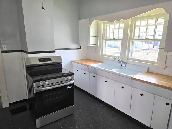 a kitchen with appliances a sink and a window