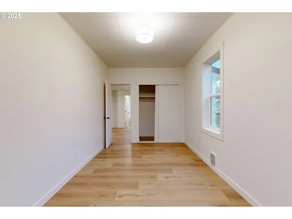 a view of an empty room with wooden floor