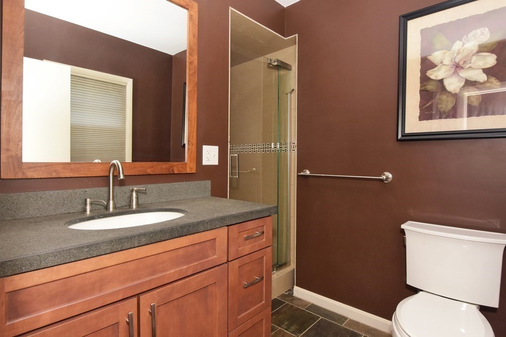 64 Kinnicutt Road Worcester, MA 01602 - Photo 16 of 38 a bathroom with a granite countertop toilet sink and mirror