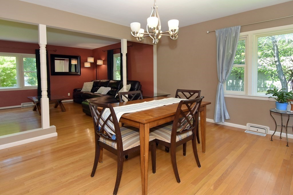 64 Kinnicutt Road Worcester, MA 01602 - Photo 9 of 38 a dining room with wooden floor a chandelier a wooden table and chairs