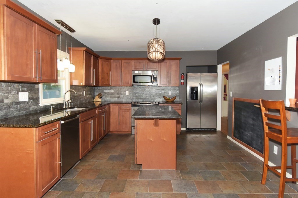64 Kinnicutt Road Worcester, MA 01602 - Photo 10 of 38 a kitchen with stainless steel appliances granite countertop a refrigerator a sink dishwasher a stove with wooden cabinets and floor